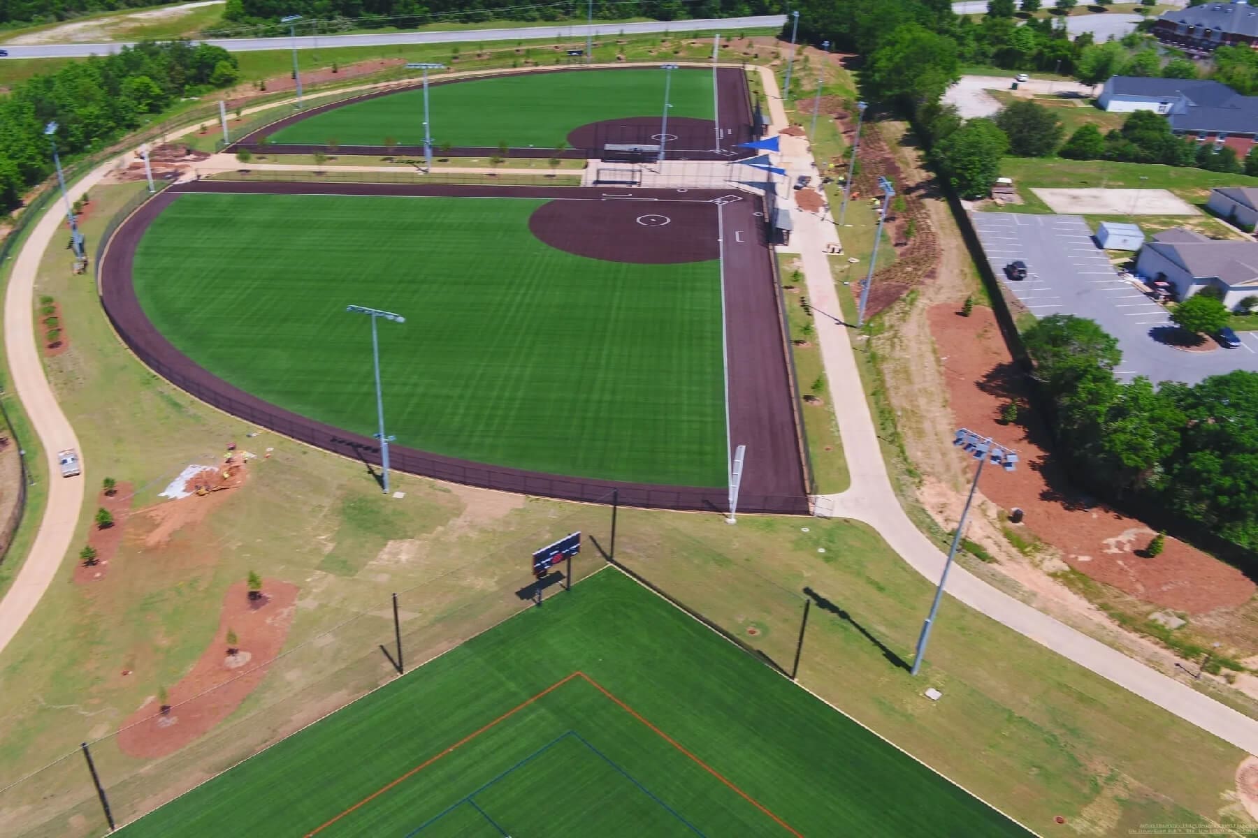 A baseball field with green grass and purple turf.